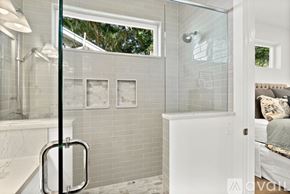 St. Augustine house for rent - A bathroom with a glass shower door and a white tub.