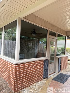 Moultrie house for rent - A house with a brick wall and a window with a fan.
