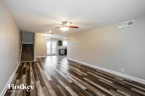 Clarksville house for rent - A spacious room with wooden flooring and a ceiling fan.