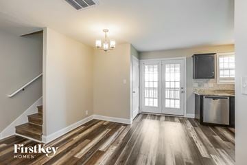 Clarksville house for rent - A kitchen area with a stainless steel dishwasher and a fridge with a microwave above it.
