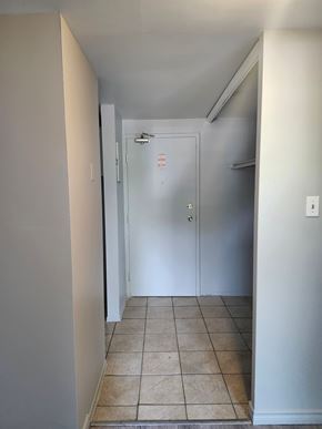 Amherstview apartment for rent - A white door with a glass window is in the middle of a hallway.