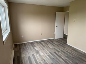 Amherstview apartment for rent - A room with a wooden floor and a white door.