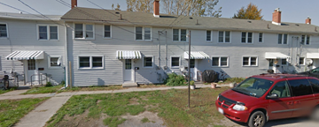 Picton apartment for rent - A red car is parked in front of a grey building.
