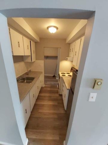 Belleville apartment for rent - A kitchen with white cabinets and wooden floors.