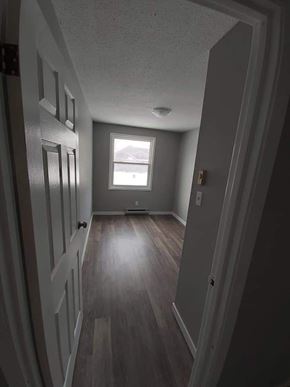Belleville apartment for rent - A hallway with wood floors and white walls.