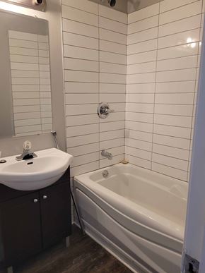 Smiths Falls apartment for rent - A white sink with a mirror above it and a white bathtub in a bathroom.