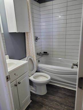 Smiths Falls apartment for rent - A white toilet sits in a bathroom next to a bathtub.