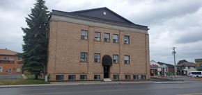 Cornwall apartment for rent - A large brick building with a black roof and a black door.