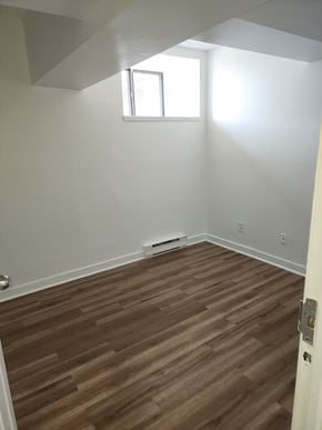 Cornwall apartment for rent - A room with a brown wooden floor and a window.