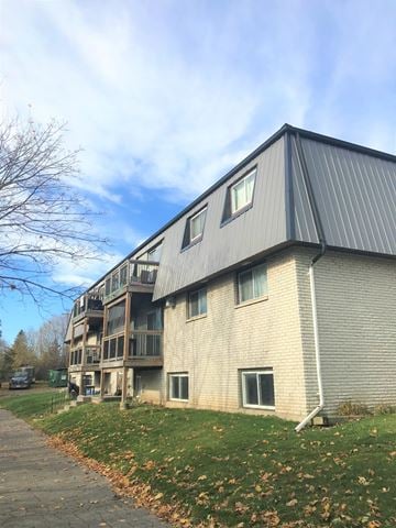 Amherstview apartment for rent - A building with a grey roof and a balcony.
