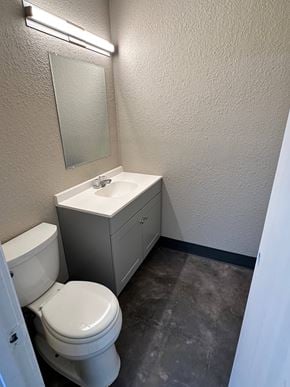 Bay City apartment for rent - A bathroom with a toilet, sink, and mirror.