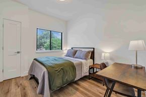 Twin Falls house for rent - A bedroom with a bed, a table, and a window.