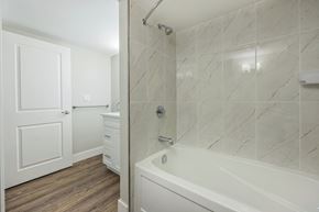 London apartment for rent - A white bathroom with a marble tile shower.