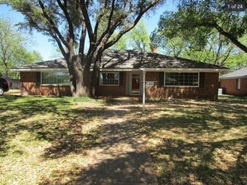 Abilene house for rent - A house with a tree in front of it.