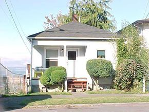 Everett apartment for rent - A white house with a black roof and a tree in front of it.