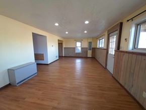 La Veta house for rent - A room with wooden floors and a grey bench.