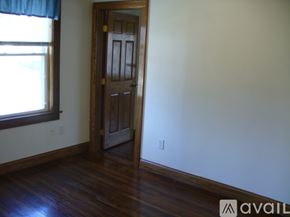 Columbus apartment for rent - A room with a wooden door and a window with a blue curtain.