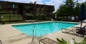 Nashville condo for rent - A swimming pool in front of a building with a blue umbrella.