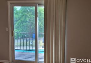 Nashville condo for rent - A white door with a glass window leading to a pool and trees.
