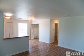 Austin apartment for rent - A room with wooden floors and white walls, with a window and a door visible.