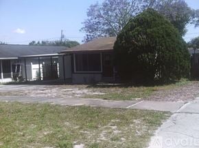 Palm Harbor house for rent - A house with a brown roof and a tree in front.