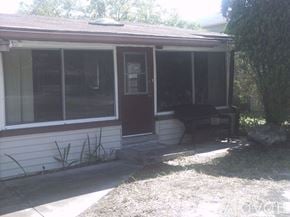 Palm Harbor house for rent - A house with a brown door and a bench outside.