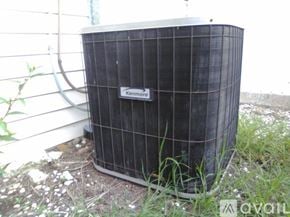 Palm Harbor house for rent - A Kenmore air conditioner unit is placed outside on the grass.