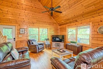 Clayton house for rent - A living room with a brown leather couch and a wooden ceiling.