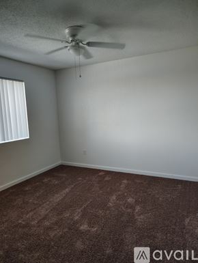Bakersfield apartment for rent - A room with a carpeted floor and a ceiling fan.