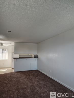 Bakersfield apartment for rent - A room with a carpeted floor and a kitchenette.