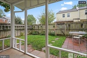 Manassas apartment for rent - A patio with a table and chairs is framed by a white railing.