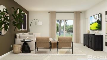 Fort Myers house for rent - A living room with a sofa, chair, and a table with a lamp on it.