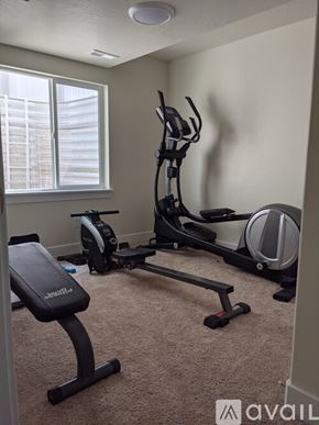 Eagle Mountain house for rent - A home gym with a treadmill, elliptical trainer, and stationary bike.
