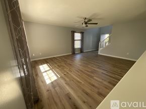 Mccordsville house for rent - A spacious room with wooden flooring and a ceiling fan.