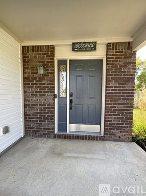 Mccordsville house for rent - A house entrance with a grey door and a sign that says "welcome".