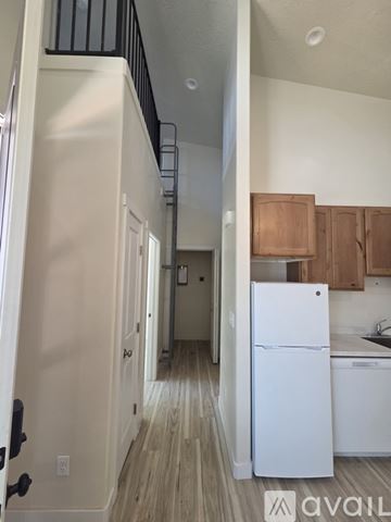 Moab townhouse for rent - A white refrigerator in a kitchen with wooden cabinets.