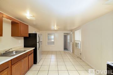St. Petersburg house for rent - A kitchen with a black refrigerator and wooden cabinets.