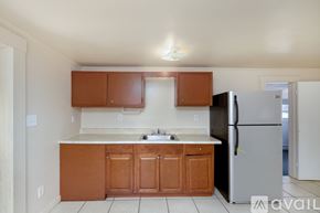 St. Petersburg house for rent - A kitchen with brown cabinets and a black refrigerator.