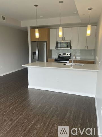 Denver apartment for rent - A kitchen with a white counter top and wooden floors.