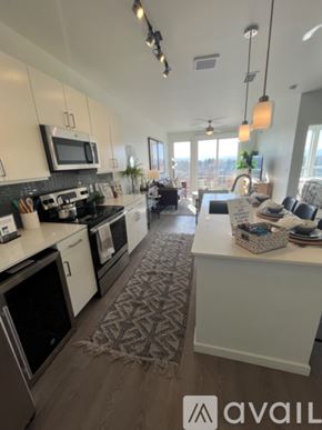 Denver apartment for rent - A kitchen with white cabinets and a patterned rug on the floor.