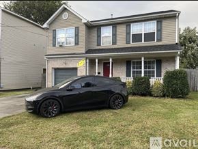 Norfolk house for rent - A black car is parked in front of a two-story house.