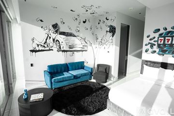 Las Vegas apartment for rent - A living room with a blue couch and a painting of a man with a car and money.
