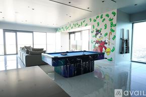 Las Vegas apartment for rent - A room with a pool table and a wall with cartoon characters on it.