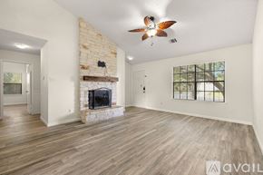 Round Rock house for rent - A spacious living room with a fireplace and a ceiling fan.