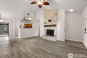 Round Rock house for rent - A living room with a fireplace and a ceiling fan.