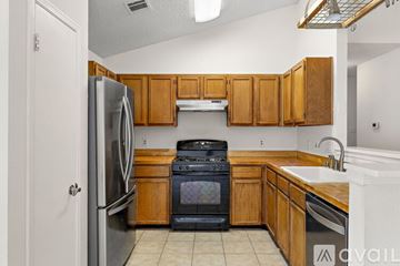 Round Rock house for rent - A kitchen with wooden cabinets and a black oven.