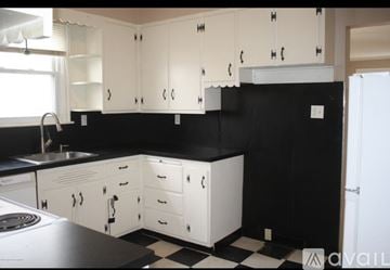 Scranton apartment for rent - A kitchen with black countertops and white cabinets.
