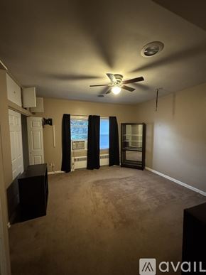 Scranton apartment for rent - A room with a ceiling fan and a window with curtains.