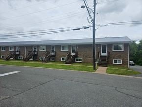 Stellarton apartment for rent - A building with a grey roof and a white car parked in front.