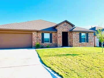 Abilene house for rent - A brick house with a garage door and a driveway.